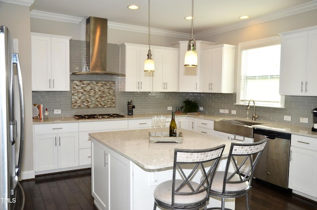 kitchen featuring decorative light fixtures, tasteful backsplash, sink, stainless steel appliances, and wall chimney exhaust hood