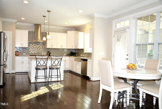 kitchen featuring white cabinetry, a center island, hanging light fixtures, appliances with stainless steel finishes, and exhaust hood