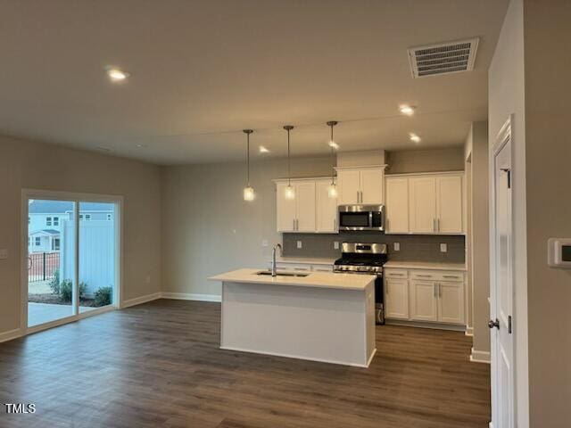 kitchen featuring sink, decorative light fixtures, a center island with sink, appliances with stainless steel finishes, and white cabinets