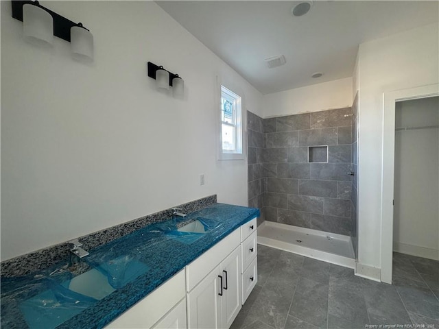 112 Peeler Cir, Raeford, NC 28376 - bathroom featuring a tile shower, vanity, and baseboards