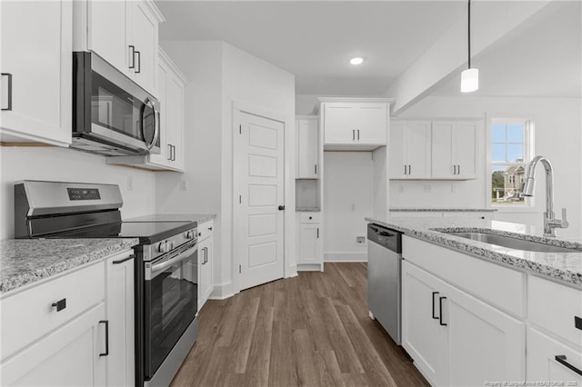 112 Peeler Cir, Raeford, NC 28376 - kitchen with appliances with stainless steel finishes, white cabinetry, dark wood-style flooring, light stone counters, and hanging light fixtures