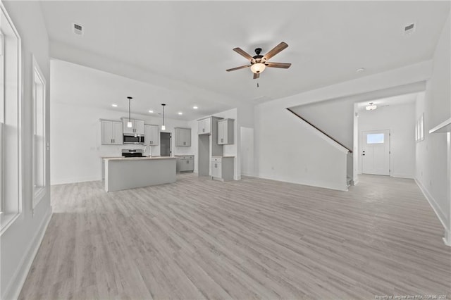142 Peeler Cir, Raeford, NC 28376 - unfurnished living room with light wood-style floors, a ceiling fan, recessed lighting, and stairs