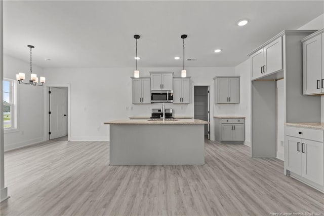 142 Peeler Cir, Raeford, NC 28376 - kitchen with stainless steel microwave, a chandelier, light wood-style floors, gray cabinetry, and recessed lighting