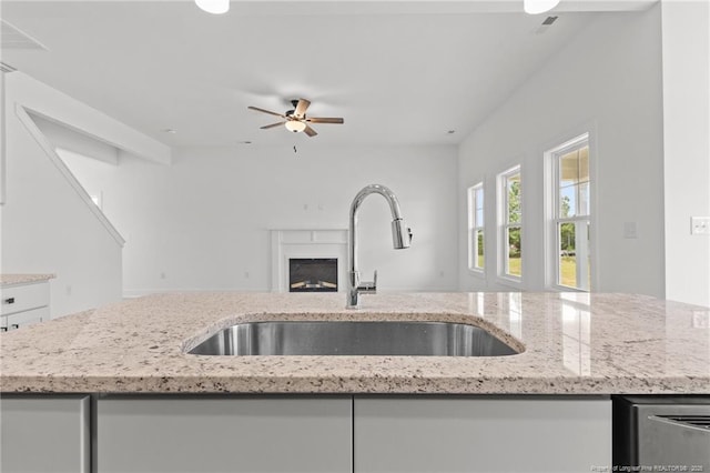 142 Peeler Cir, Raeford, NC 28376 - kitchen featuring open floor plan, light stone counters, white cabinetry, and a fireplace