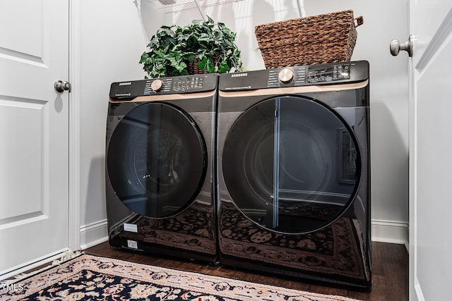 laundry room with dark hardwood / wood-style flooring and washing machine and dryer