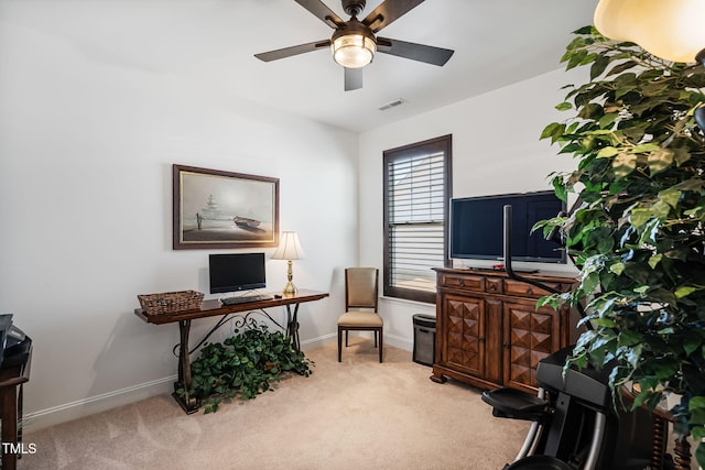 carpeted office space featuring ceiling fan