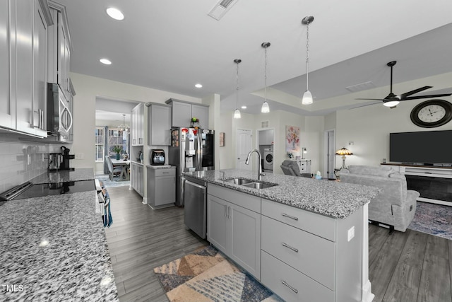 kitchen with sink, decorative light fixtures, an island with sink, and gray cabinetry