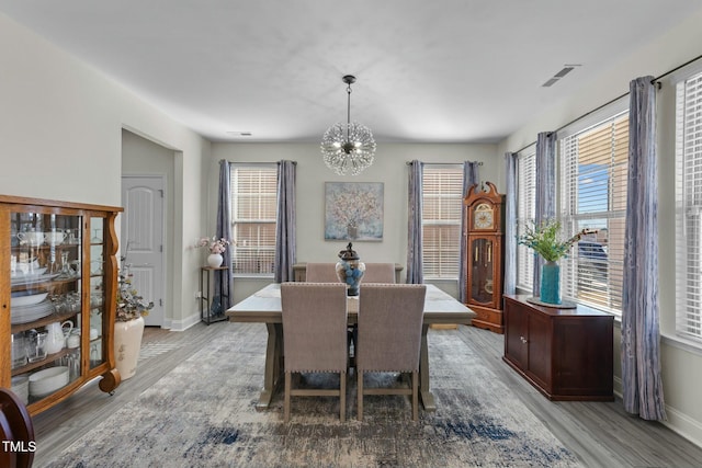 dining space featuring hardwood / wood-style floors and a chandelier