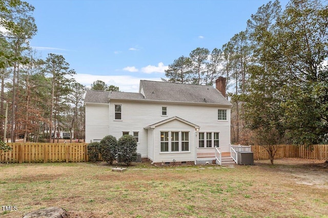 back of house featuring a lawn and a deck