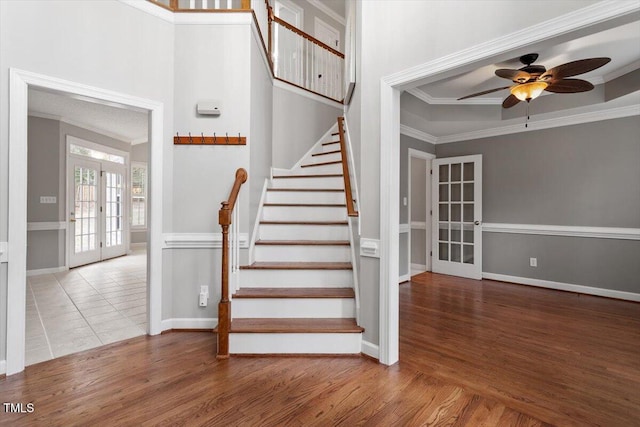 stairway featuring ornamental molding, hardwood / wood-style floors, and french doors