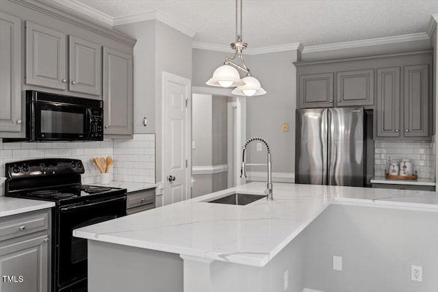 kitchen featuring light stone countertops, sink, a kitchen island with sink, and black appliances