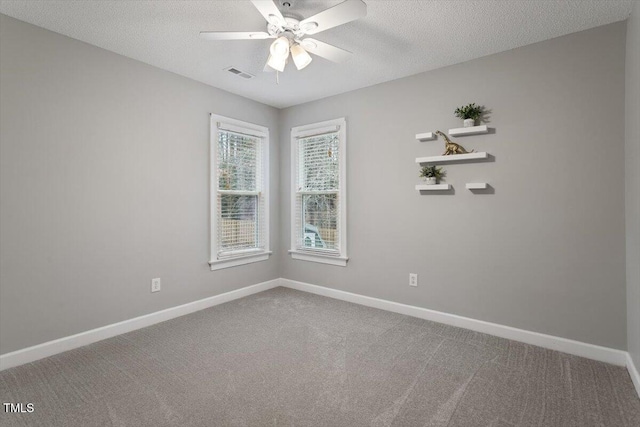 carpeted spare room featuring ceiling fan and a textured ceiling