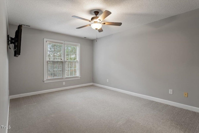 unfurnished room featuring a textured ceiling, ceiling fan, and carpet