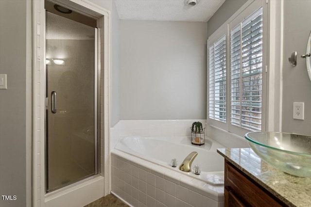 bathroom with vanity, separate shower and tub, and a textured ceiling