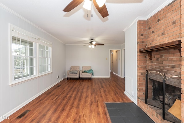 unfurnished room with a fireplace, visible vents, baseboards, dark wood-style floors, and crown molding