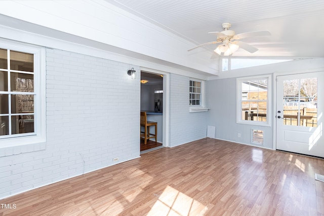 unfurnished sunroom featuring a ceiling fan and vaulted ceiling