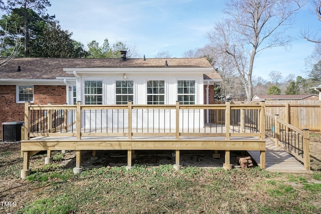 rear view of property featuring a deck, brick siding, a shingled roof, and cooling unit