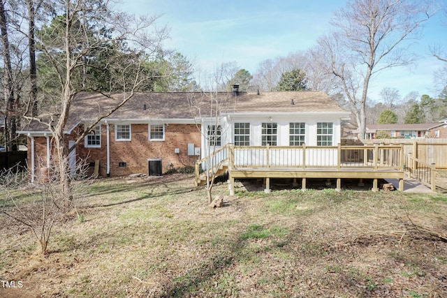 back of property with crawl space, a deck, cooling unit, and brick siding