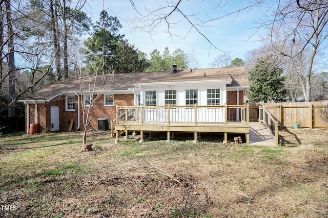 rear view of property featuring brick siding, fence, a deck, and central AC unit