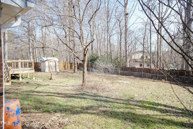 view of yard with an outbuilding, a shed, and a fenced backyard