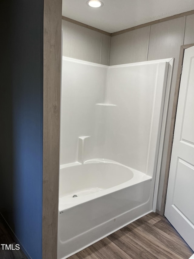 bathroom with hardwood / wood-style flooring and tub / shower combination