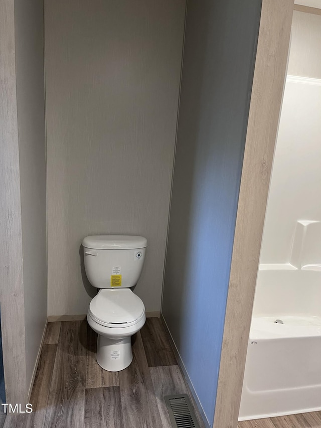 bathroom with toilet and hardwood / wood-style floors