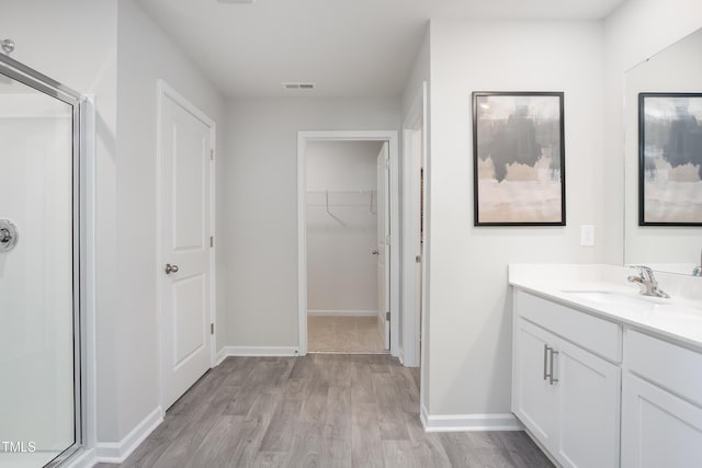 bathroom with vanity, hardwood / wood-style flooring, and a shower with shower door