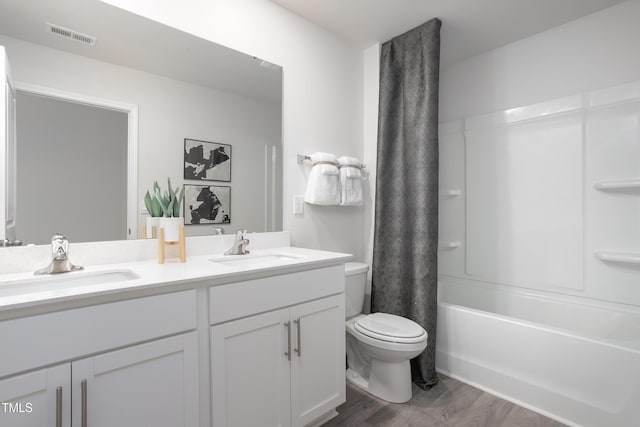 full bathroom featuring vanity, hardwood / wood-style floors, shower / bathtub combination with curtain, and toilet