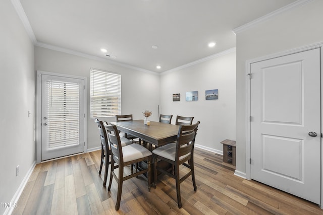 dining space with crown molding and hardwood / wood-style flooring