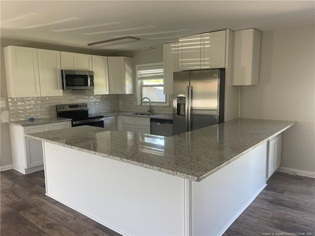 kitchen with light stone counters, sink, stainless steel appliances, and white cabinets