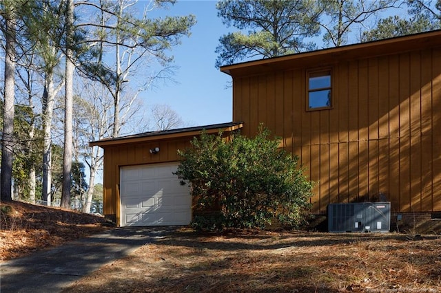 view of side of property with a garage, central AC, and an outdoor structure