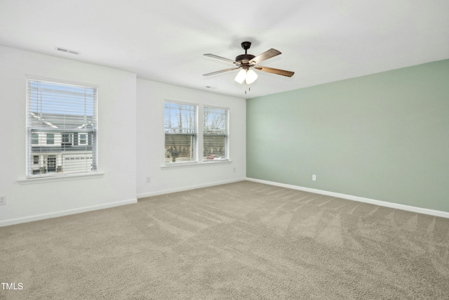 carpeted spare room featuring ceiling fan