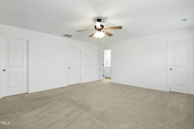 spare room featuring light carpet and ceiling fan