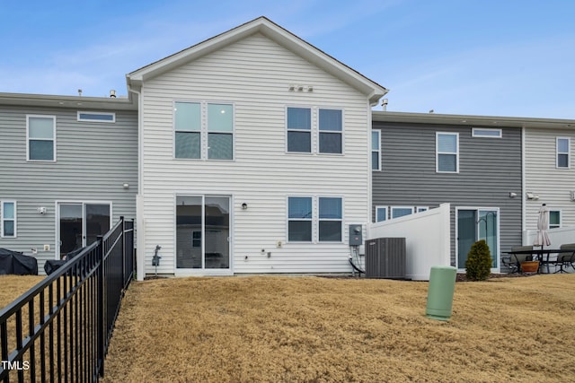 rear view of property featuring cooling unit and a yard