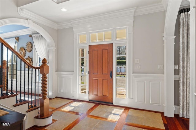 entryway with a wainscoted wall, a decorative wall, crown molding, and recessed lighting