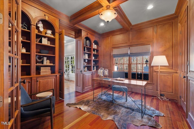 home office with crown molding, dark wood-type flooring, beamed ceiling, and a decorative wall