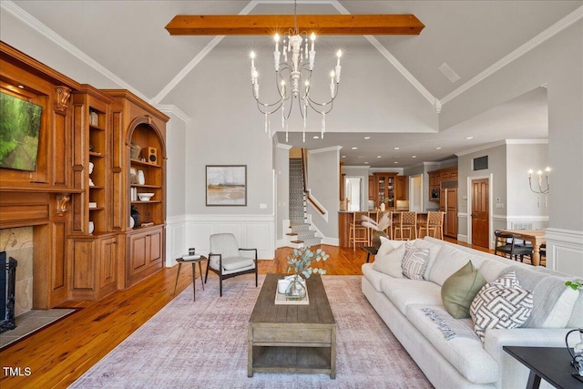 living area featuring a chandelier, wainscoting, light wood-type flooring, and a decorative wall