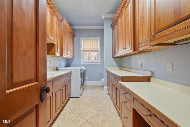 clothes washing area featuring light tile patterned flooring, separate washer and dryer, a sink, cabinet space, and crown molding