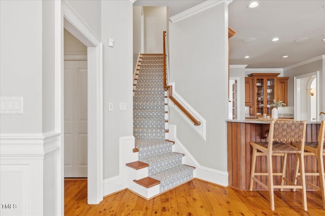 stairs featuring recessed lighting, baseboards, crown molding, and wood finished floors