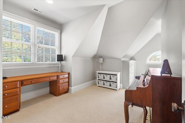 office featuring baseboards, visible vents, vaulted ceiling, and light colored carpet