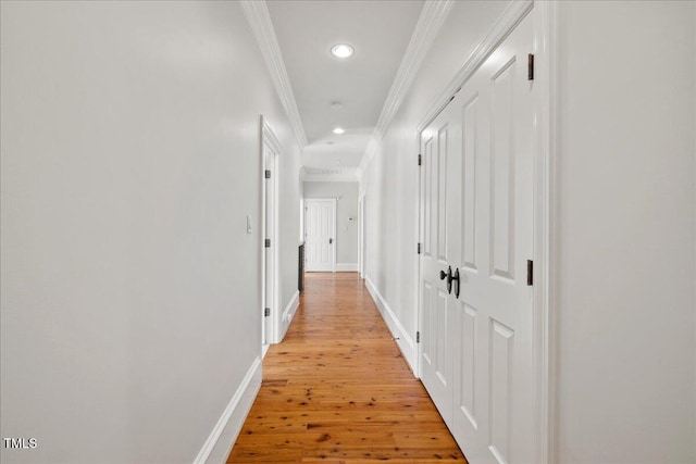 hallway featuring baseboards, recessed lighting, light wood-type flooring, and crown molding