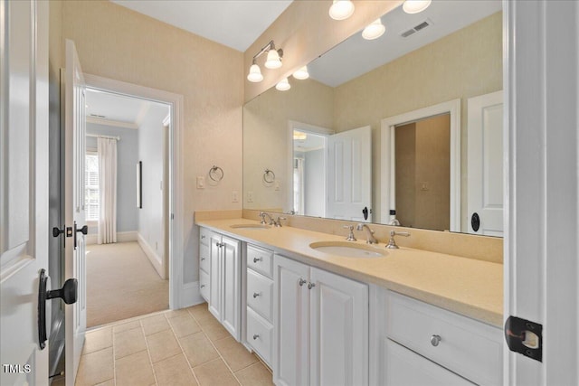 bathroom with double vanity, a sink, visible vents, and tile patterned floors