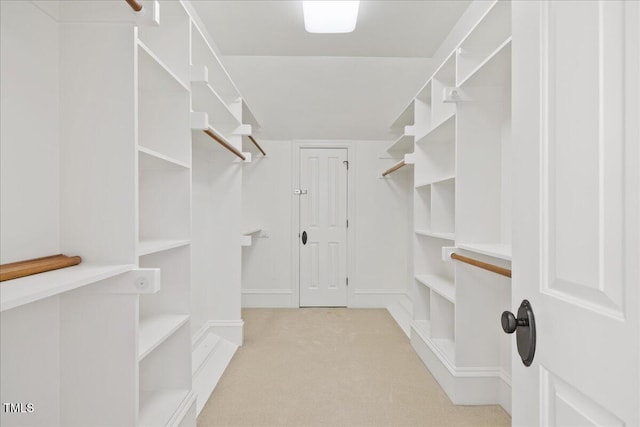 walk in closet featuring light carpet