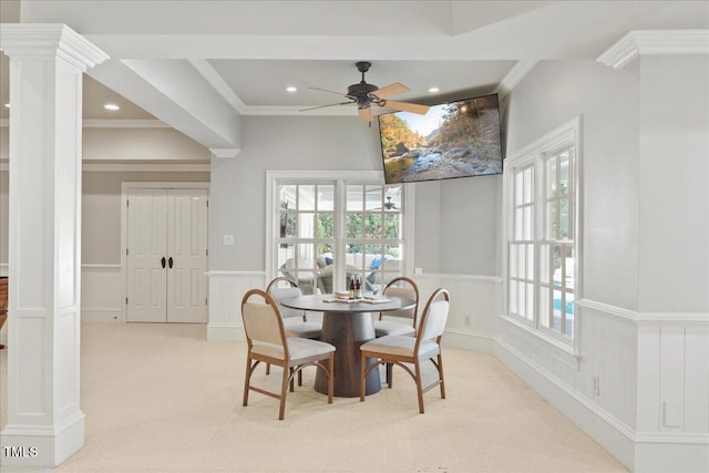 dining room with a healthy amount of sunlight, light colored carpet, and decorative columns