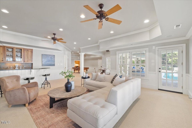 living room with decorative columns, visible vents, a decorative wall, light carpet, and wainscoting