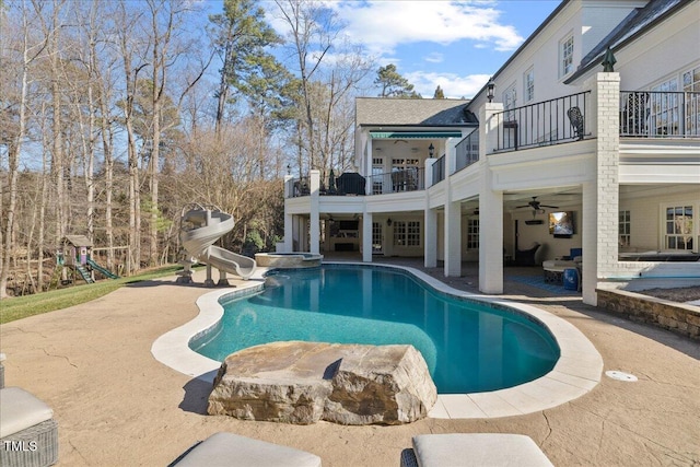 view of pool featuring a water slide, a patio area, ceiling fan, and a playground