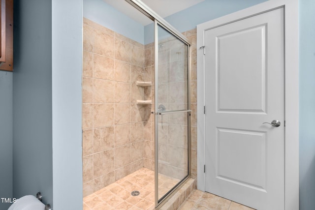 bathroom with tile patterned floors and a shower with door