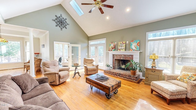 living room featuring a fireplace, a wealth of natural light, light hardwood / wood-style flooring, and high vaulted ceiling