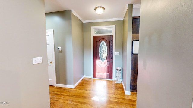 entryway with crown molding and light wood-type flooring