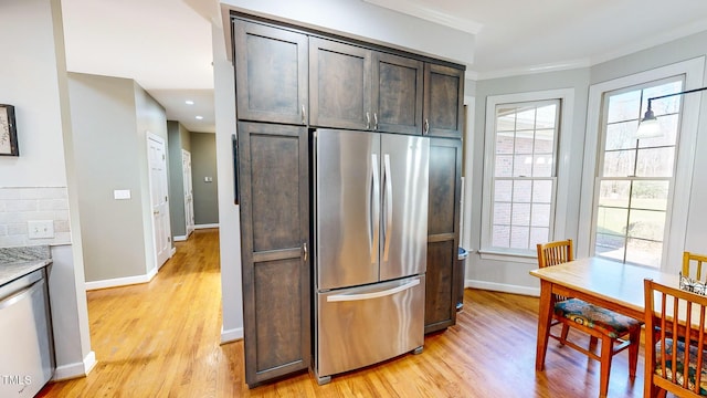 kitchen with dark brown cabinetry, stainless steel appliances, light hardwood / wood-style flooring, and a wealth of natural light